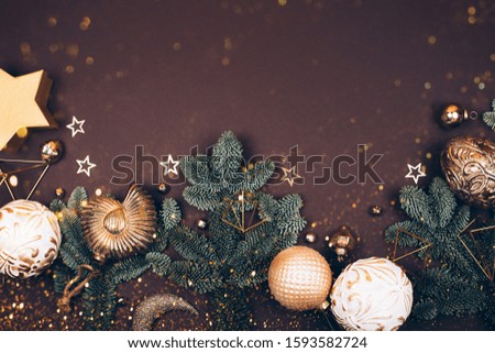 Christmas decorations on dark background. Fir tree, golden toys, sparkles and lights. Place for your text