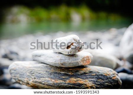 Balanced stone on a peddle Stones balance and wellness retro spa concept, peaceful and unique inspiration, zen-like and well being tranquil composition. Closeup of white pebbles stack near lake