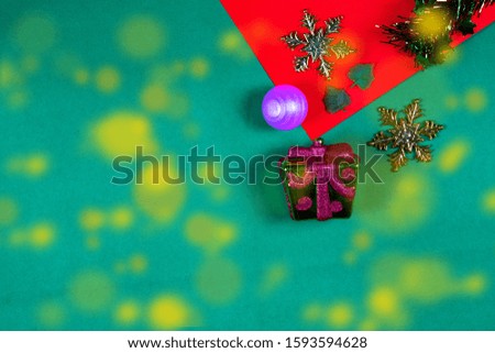 Christmas bauble,snow flake ,presents ,star and leaves on Red green background with snow fall,top  view with copy space