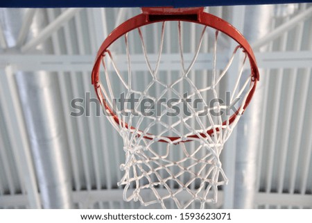 empty red basketball Hoop and white net in indoor gym, close-up
