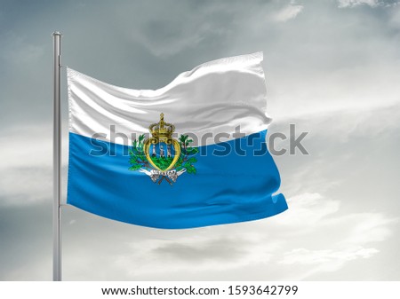 San Marino national flag cloth fabric waving on beautiful grey sky.