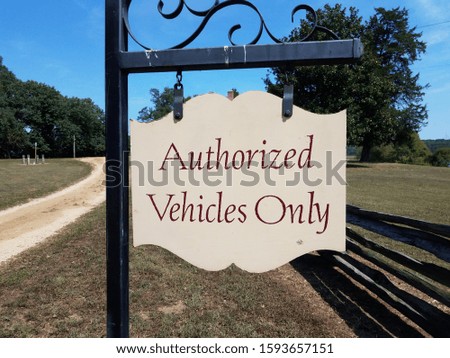 authorized vehicles only sign with wood fence and grass