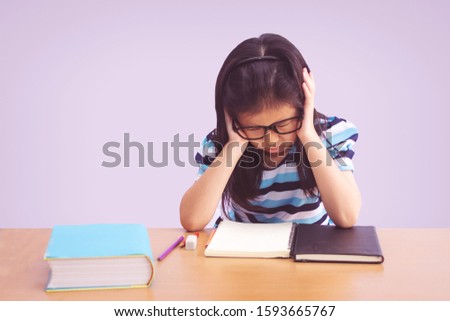 Bored and tired asian student girl doing homework 