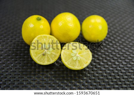 half cut and full pulpy and juicy lemons on textured backdrop