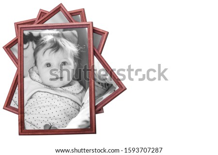 Black and white photograph of baby in a brown wooden frame