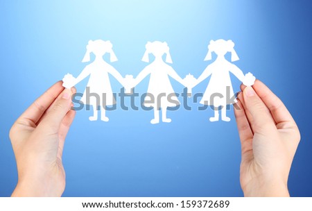Paper people in hands on blue background
