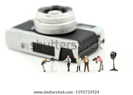 Miniature people : cameraman ,Videographer at work shooting on film camera.
