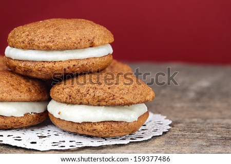 Stack of homemade Pumpkin Whoopie Pies or Moon Pies made with cream cheese frosting. 