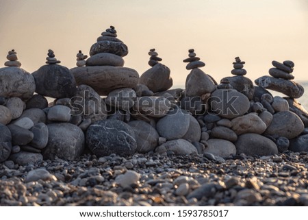 on the pebbly beach, a wall of stones was piled on top of each other in the form of pyramids and towers to build such a need very smooth movement and harmony