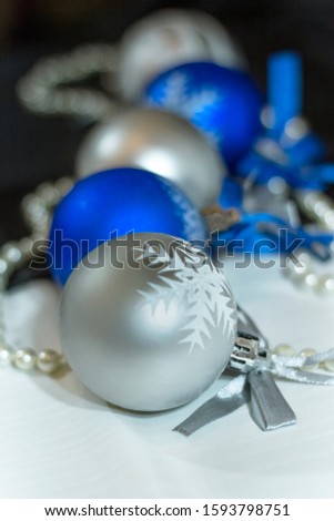 silver blue ball with snowflake in white and black background. Christmas card in vertical view
