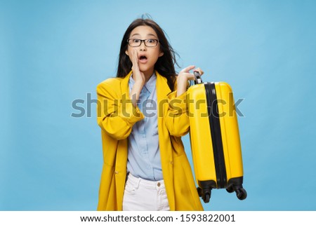 Yellow suitcase woman travel blue passport background