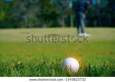  Blurred golf ball on green in the evening golf course with sunshine in thailand                              