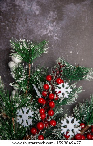 Christmas fir twigs with red berries and snowflakes  on dark background copyspace