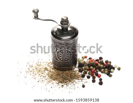 Retro silver pepper mill with mixed pepper grains and crushed, minced flakes isolated on white background