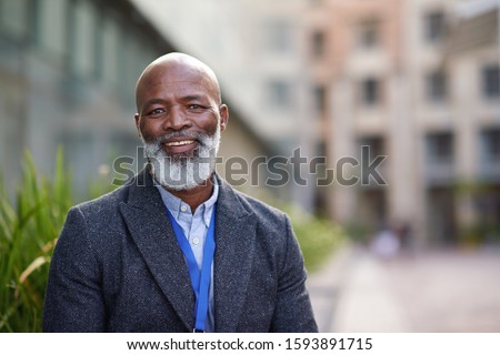 Portrait mature african american businessman smiling happy in city Royalty-Free Stock Photo #1593891715