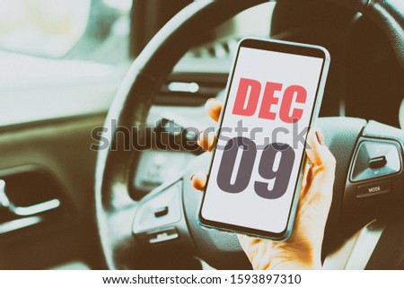 december 9th. Day 9 of month,Calendar date. Month and day placed on a smartphone screen in womans hand in car interior. artistic coloring.  winter month, day of the year concept