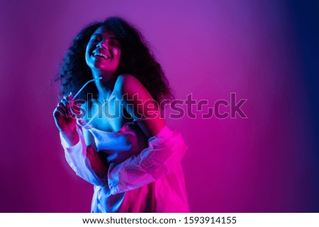 Happy beautiful fashion young african american girl hipster black woman hold stylish glasses. wear raincoat look at camera laughing dancing isolated on disco party purple pink trendy studio background
