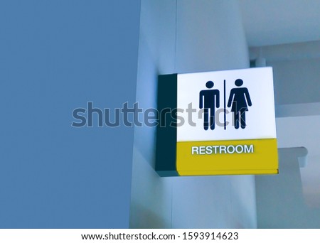 Yellow toilet or rest room sign on blue wall  with man, woman icon set  symbol background, modern, hygiene and clean restroom concept
