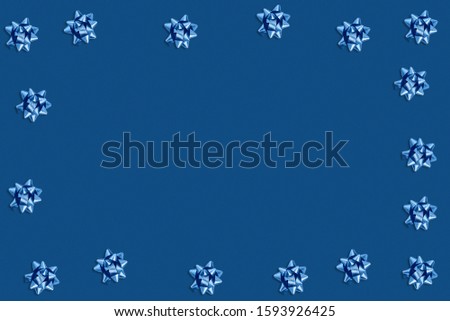 Christmas and new year pattern. Celebration picture. Pink background with classic blue bright bows. Flat lay, top view, copy space.