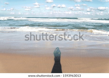 Woman figure shadow taking a photo in surfers paradise beach with beauiiful waves, blue sky and some clouds, concept of freedom, Gold Coast, Queensland, Australia