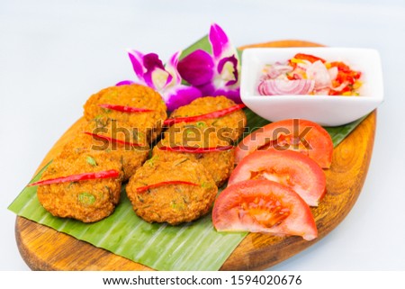 Picture of Thai food called fish cakes mixed with Thai spices and sweet sauces, a traditional Thai food that is popular all over the world on a beautiful tray.