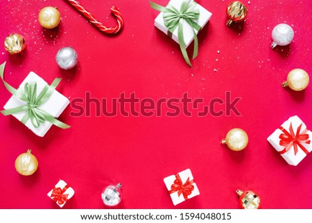 Chrismas balls, christmas gifts and caramel cane isolated on red background. Concept of Christmas and new year.
