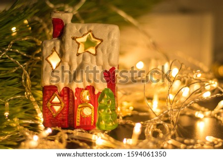 Small house model or toy house decoration on table with bokeh background. New Year mood. Comfort. Magic