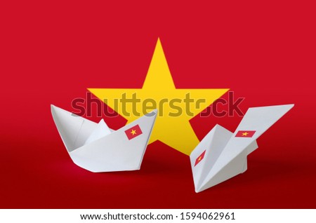Vietnam flag depicted on paper origami airplane and boat. Handmade arts concept