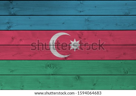 Azerbaijan flag depicted in bright paint colors on old wooden wall. Textured banner on rough background