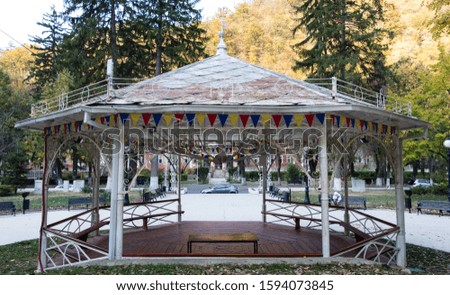 Pavilion in the park. Wooden and iron structure gazebo in a garden park. Relaxing place with a pavilion with bench. A good place where spend time to rest. Beautiful autumn day. Herculane baths
