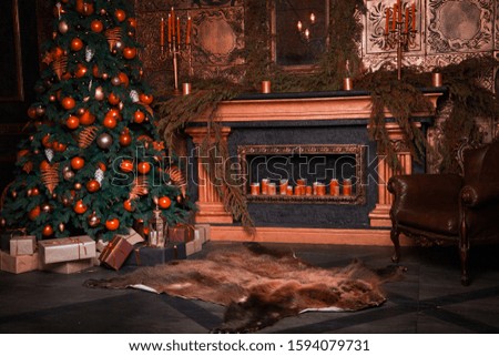 a tree near the fireplace, a brown leather chair stands on the floor

