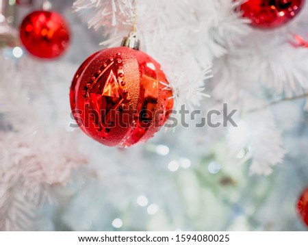 Photo of red baubles decorated on a beautiful white Christmas tree.