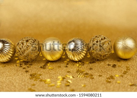 Christmas toys on a gold background. Christmas golden balls. Christmas motives. New Year. Holidays.