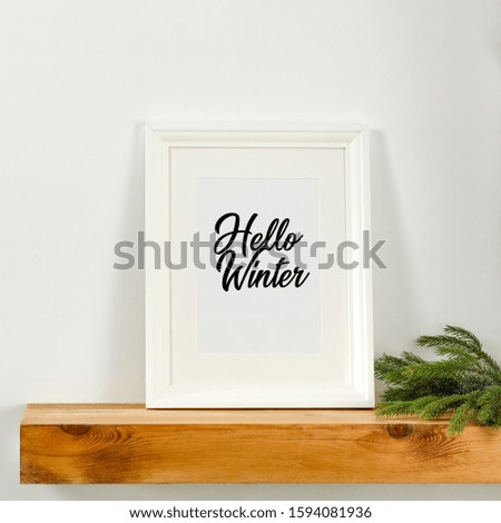 Winter background of wooden shelf with empty frame for your decoration.Xmas time and chrsitmas decoration.Copy space and white wall background.