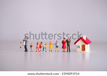 Miniature people, big family standing with mini house using as family concept