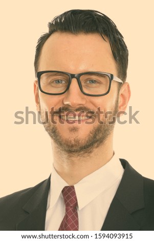 Face of young happy businessman smiling while wearing eyeglasses