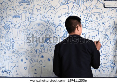 Drawing picture on white board by Thai male student.