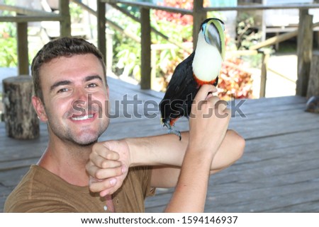 Man interacting with a gorgeous toucan bird 