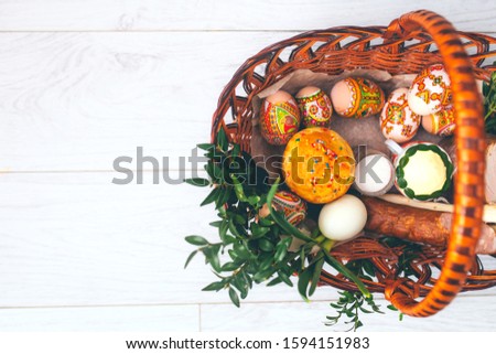 Ukrainian easter basket background. Traditional easter cake kulich  with colored eggs in a basket.