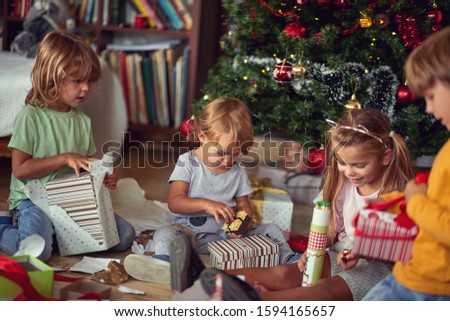 Family at  Christmas. Happy Children under Christmas tree with presents.