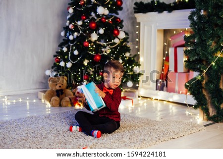 little boy opens Christmas presents new year Christmas tree Garland
