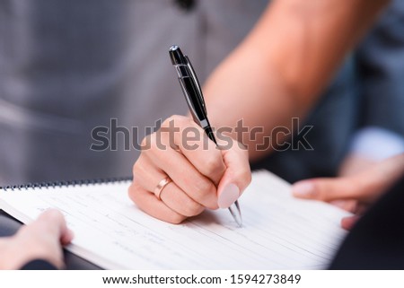 Business woman signing paper document,close up.Female hand in formal suit writing important agreement.Bride on wedding sign deal contract