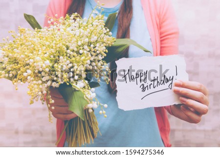 Happy birthday card with lettering and bouquet lily of the valley flowers, anniversary celebration 