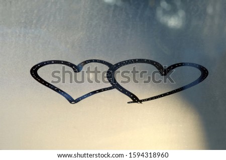 Heart drawn with a finger on the fogged glass window. Close up.