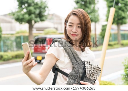 japanese mother holding baby takes selfie
