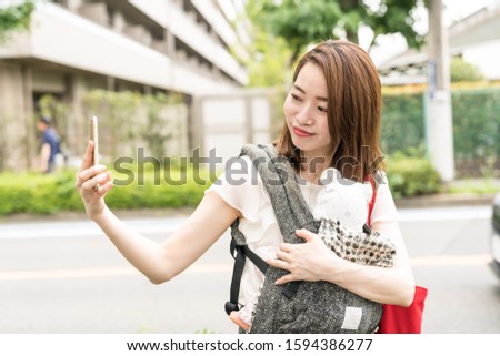japanese mother holding baby takes selfie