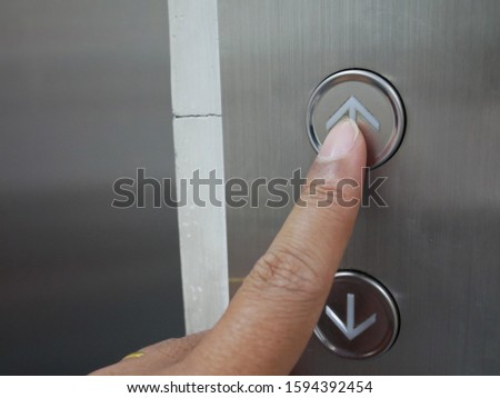 closeup of hand pressing on the elevator button.