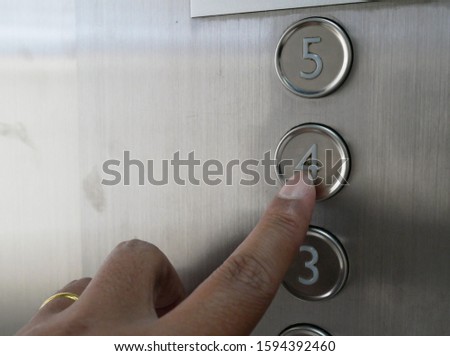 closeup of hand pressing on the elevator button.