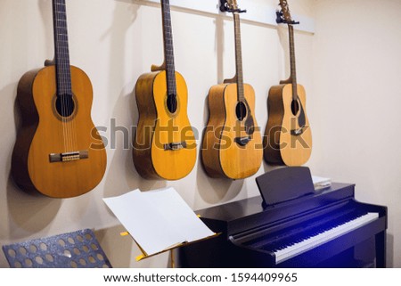 Selective focus to classical guitars with piano in music room. There are musical instrument for learning music.