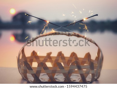 Sparkler and bamboo basket at sunset
